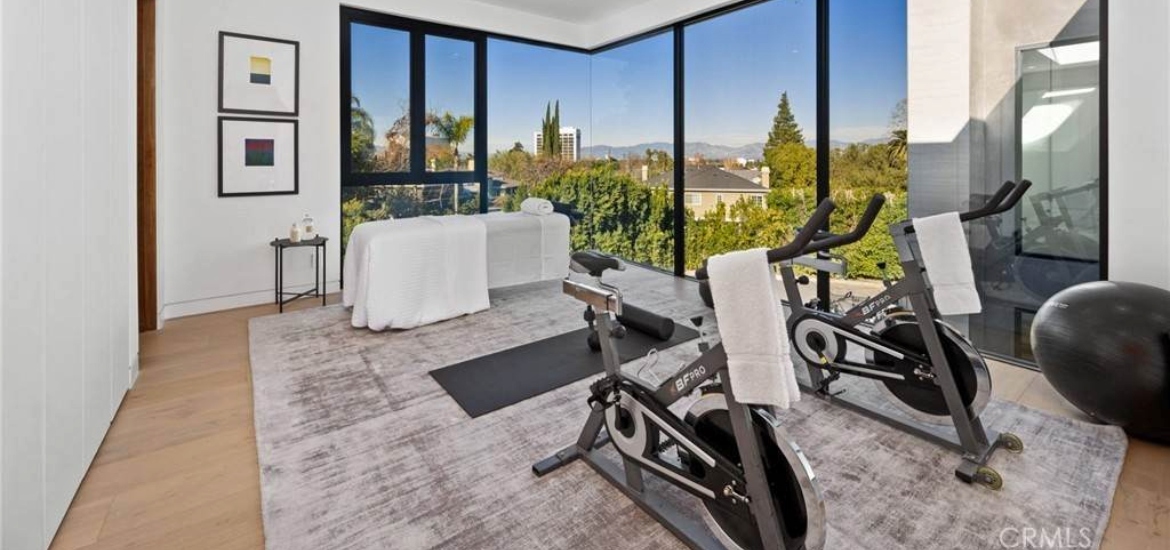 fitness area with natural light and gym equipment in a luxury los angeles rental house 