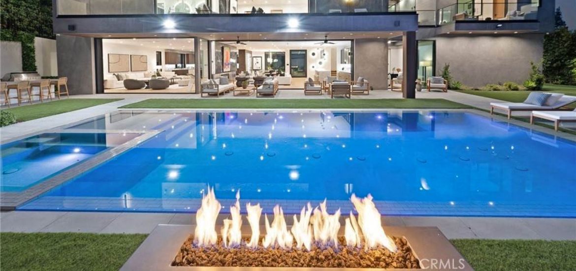 clear pool with a fire pit at night in a luxury los angeles rental house