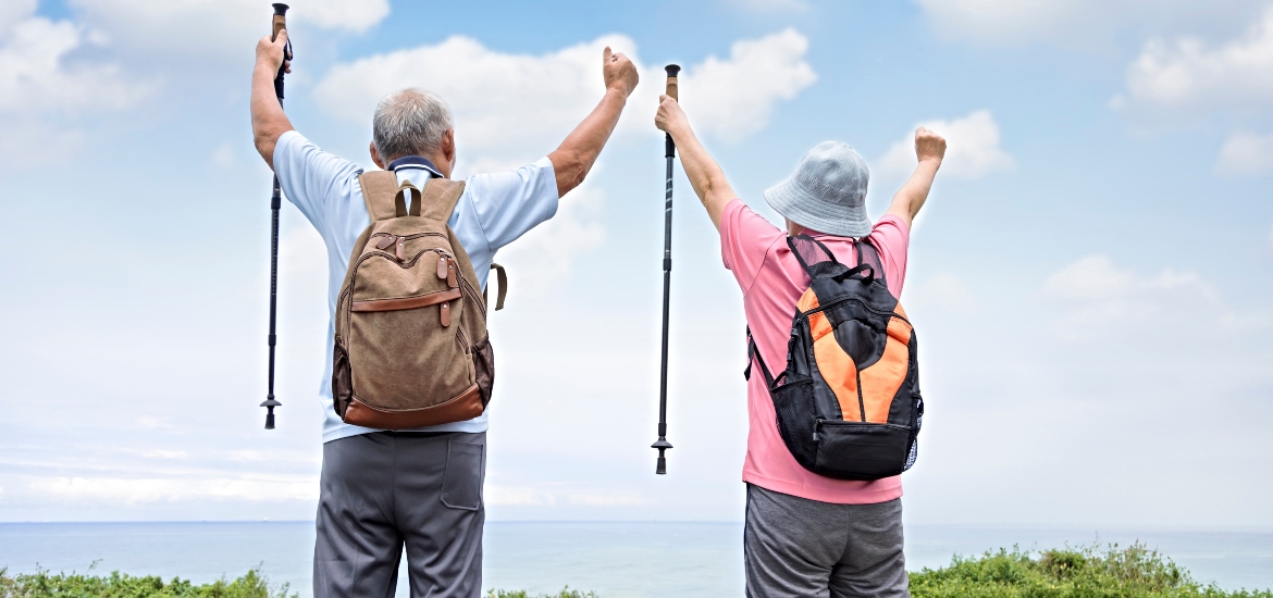 Rear view of happy snowbirds hiking together while escaping winter