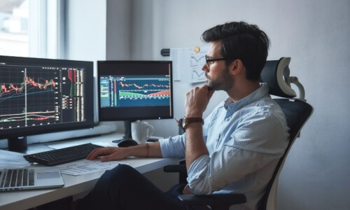 business man looking at charts on computer monitors