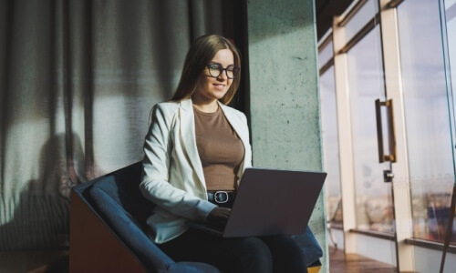 young woman writing on laptop